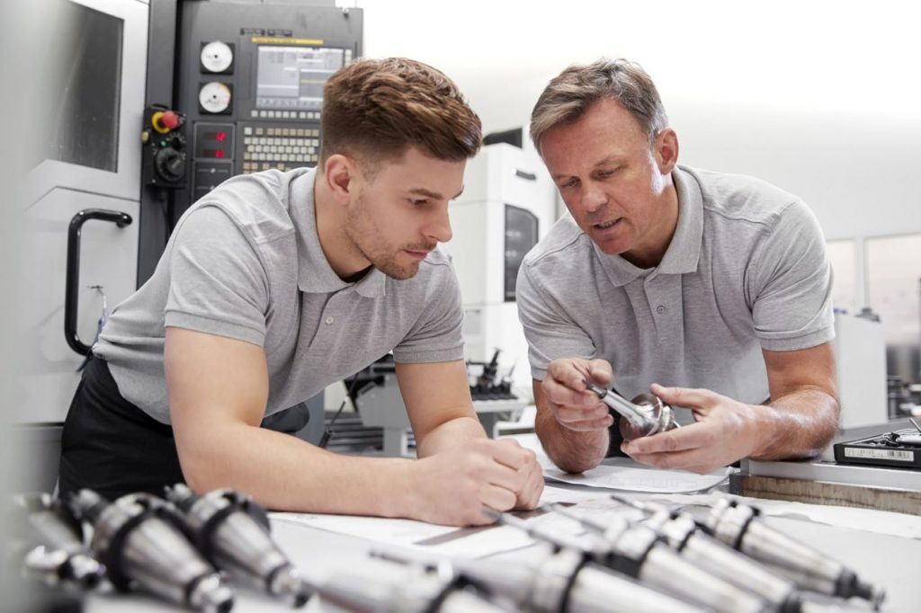 Engineer Showing Apprentice How To Measure CAD Drawings szkolenia